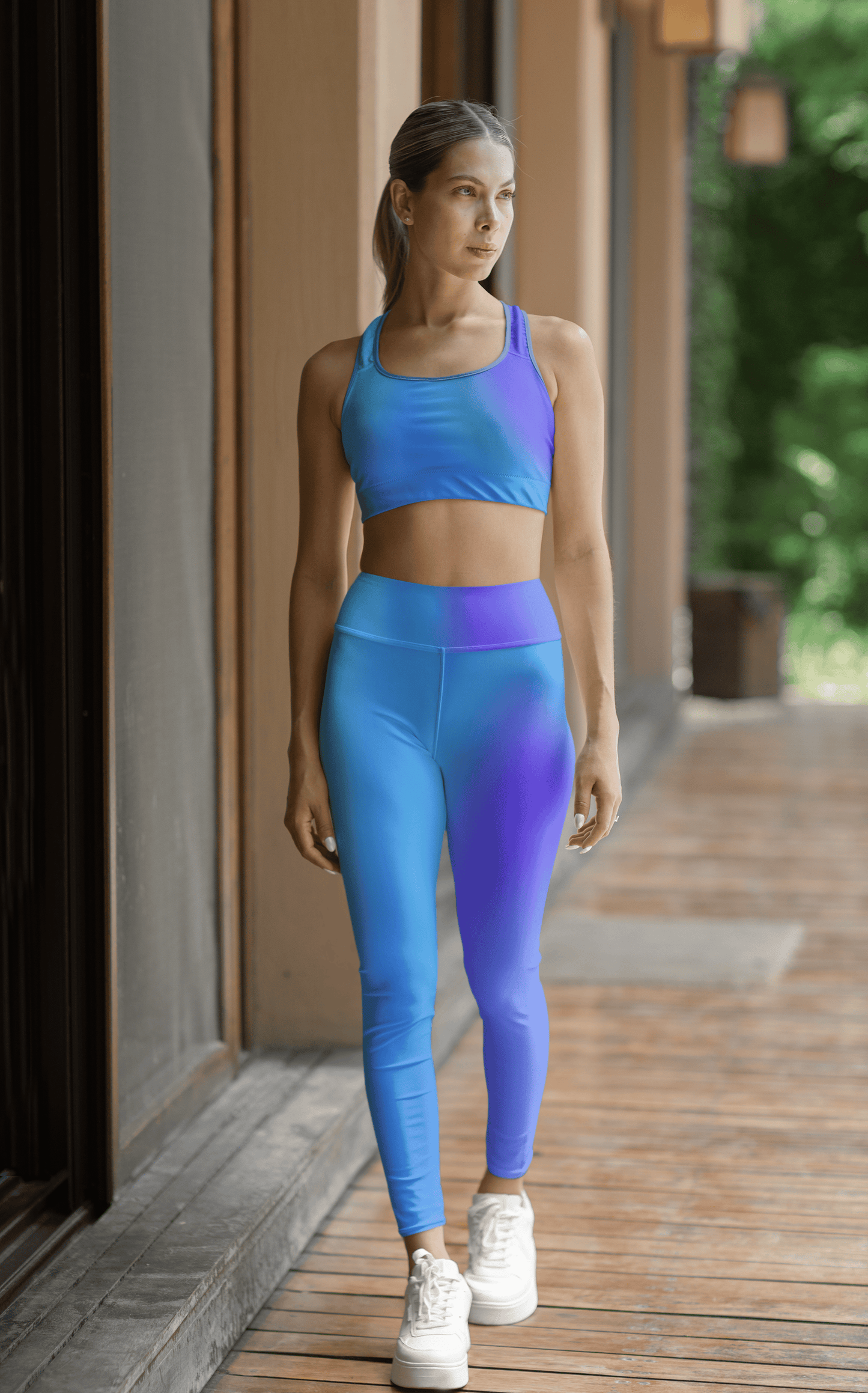 Woman in Vibrant Gradient Blue High Waist Yoga Leggings and sports bra set on a wooden deck. - Printspirationz