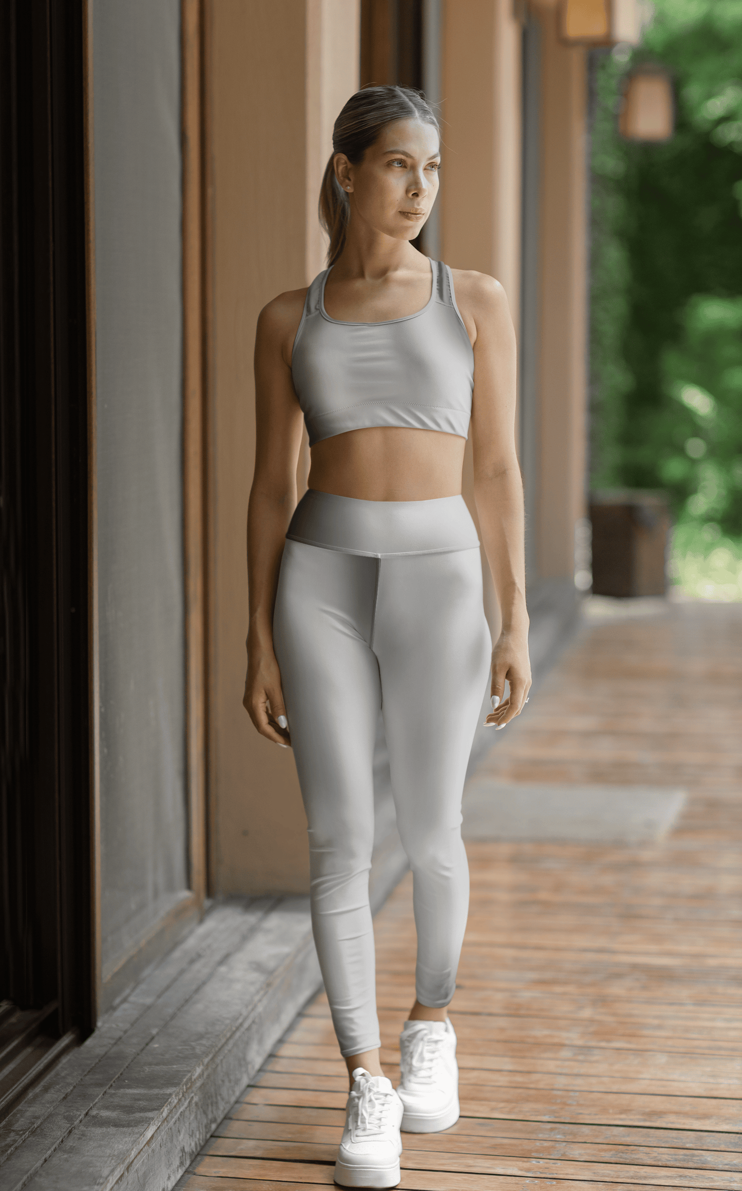 Woman wearing Printify all over prints high waist yoga leggings and matching sports bra walking outdoors