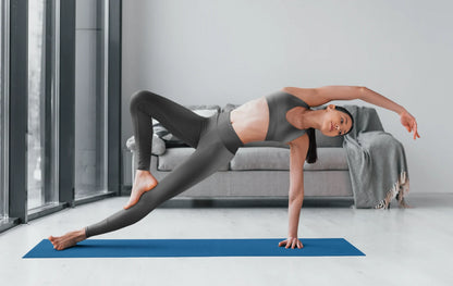 Woman practicing yoga indoors wearing black colored High Waist Yoga Leggings activewear leggings on blue mat - Printspirationz