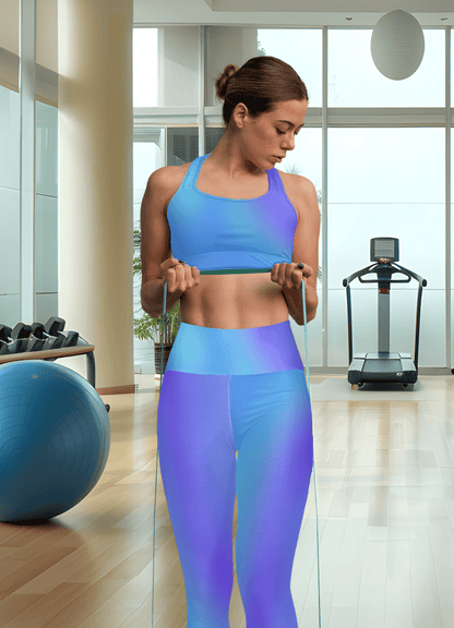 Woman in Vibrant Gradient Blue High Waist Yoga Leggings, exercising with resistance bands in a gym setting - Printspirationz