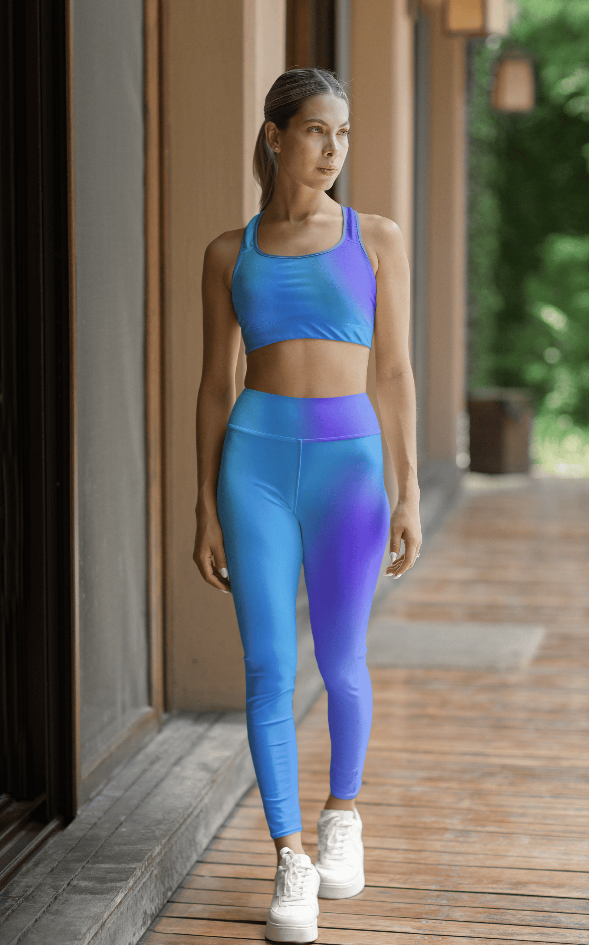 Woman in Vibrant Gradient Blue High Waist Yoga Leggings and sports bra set on a wooden deck. - Printspirationz