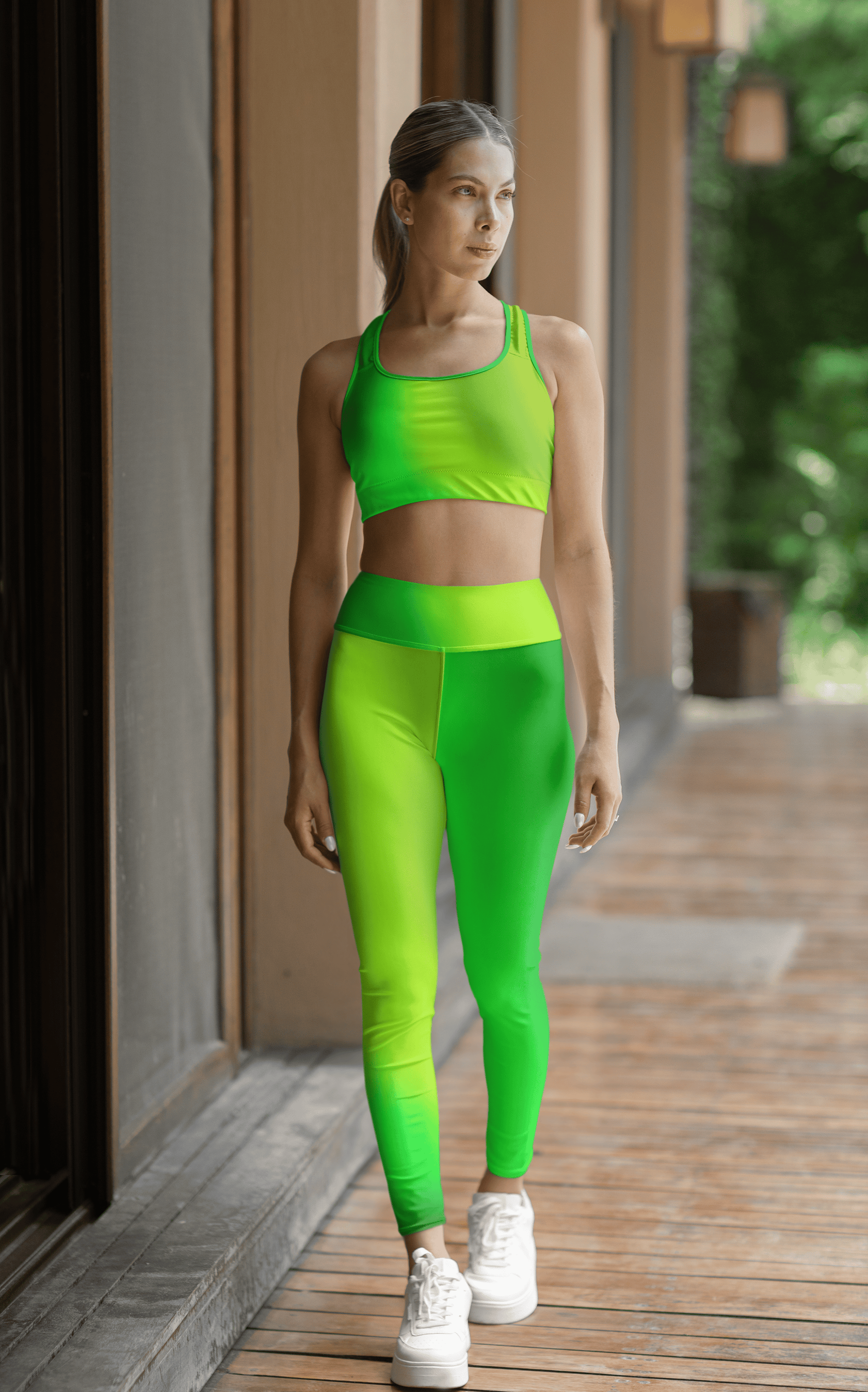 Woman in Vibrant Gradient Green High Waist Yoga Leggings and sports bra set on a wooden deck. - Printspirationz