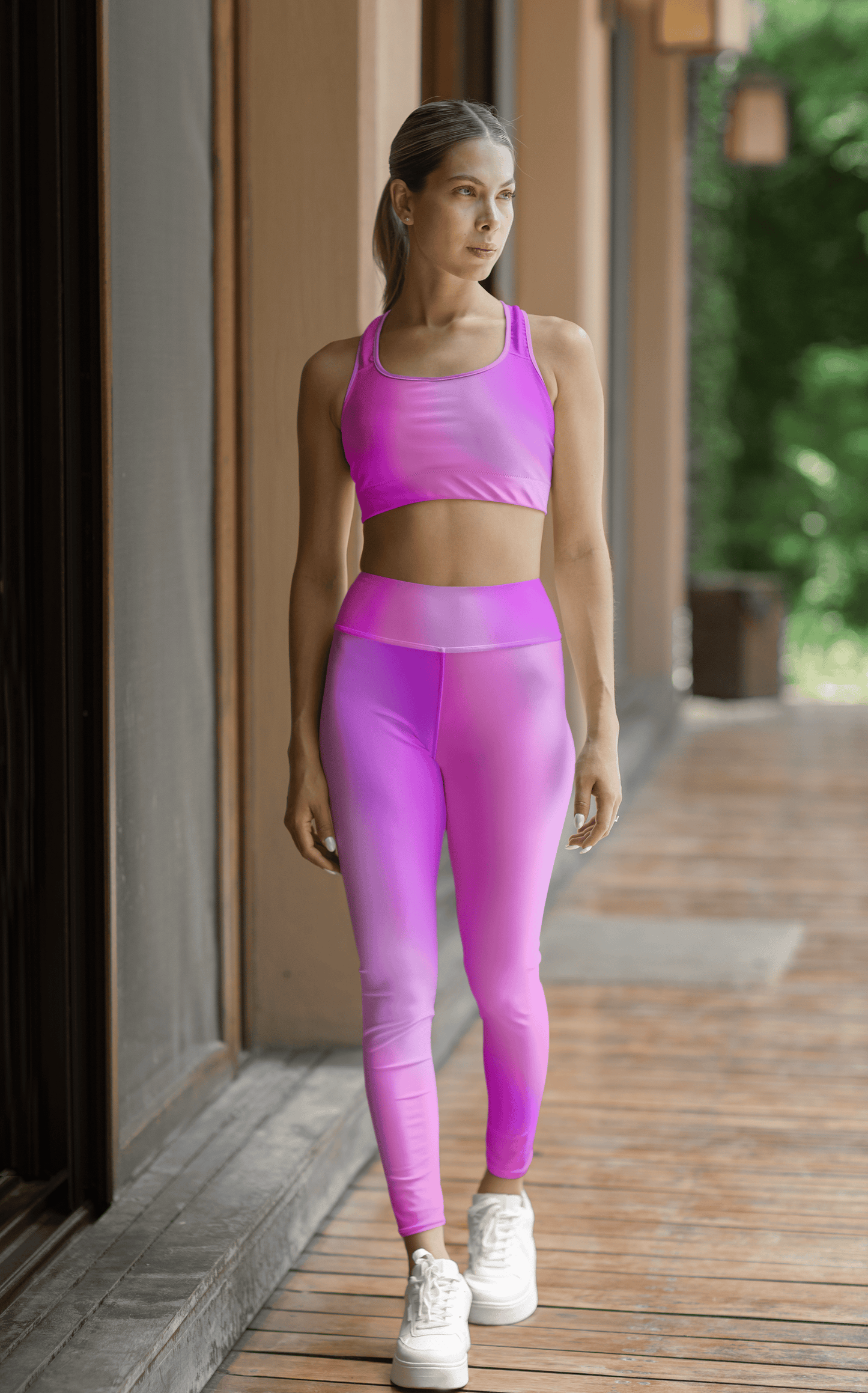 Woman in Vibrant Gradient Pink High Waist Yoga Leggings and sports bra set on a wooden deck. - Printspirationz