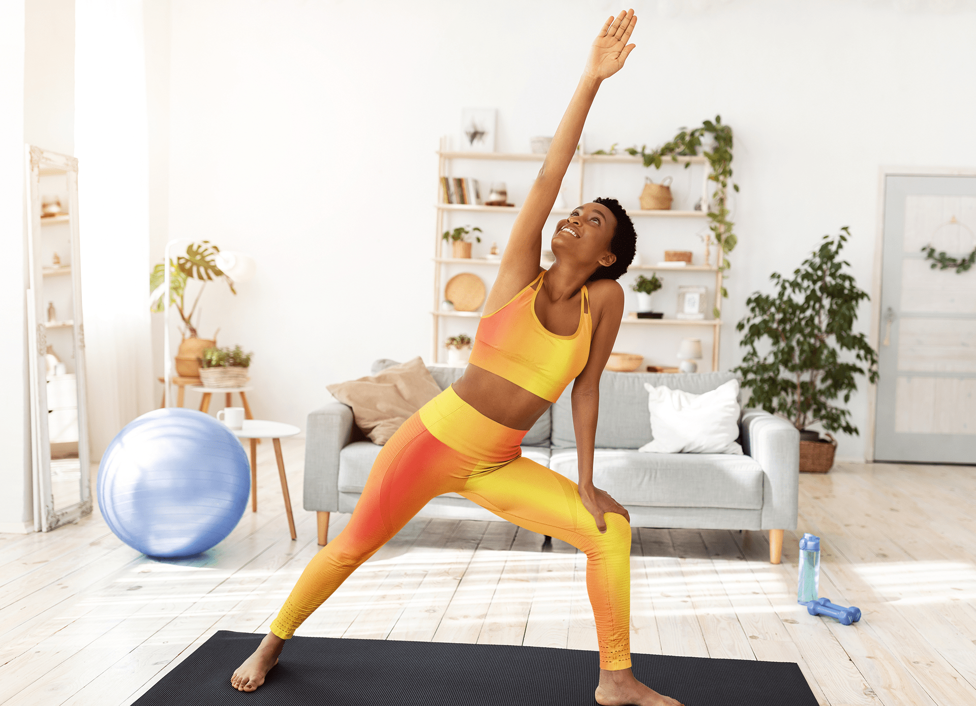 Woman in Vibrant Gradient Warm Colors High Waist Yoga Leggings  doing yoga stretch on black mat in living room - Printspirationz