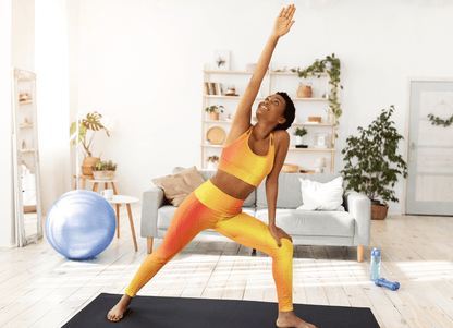Woman in Vibrant Gradient Warm Colors High Waist Yoga Leggings  doing yoga stretch on black mat in living room - Printspirationz
