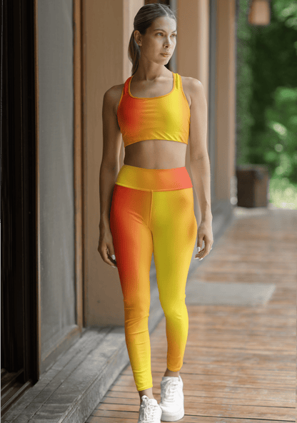 Woman in Vibrant Gradient Warm Colors High Waist Yoga Leggings  and sports bra set on a wooden deck. - Printspirationz