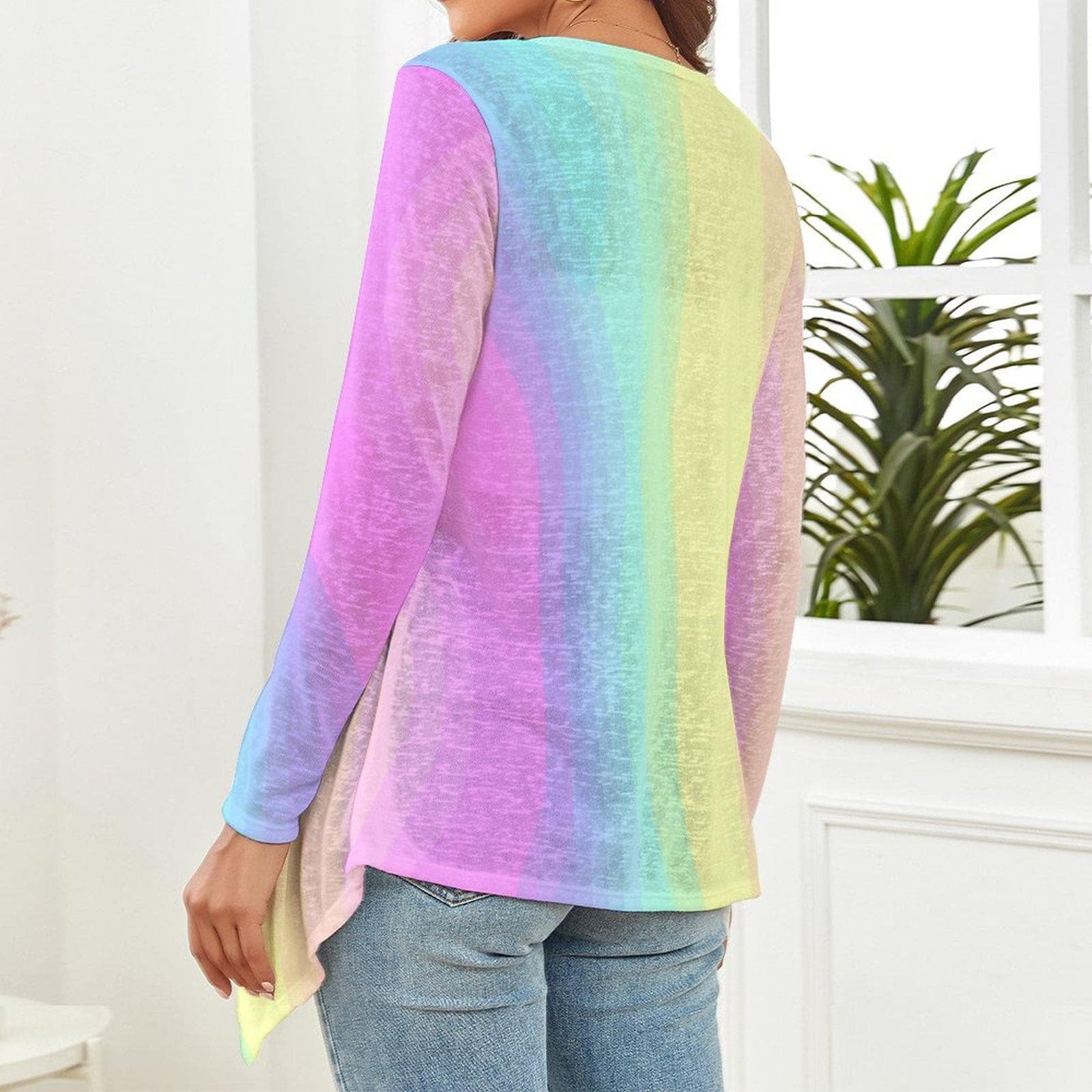The backside of a woman wearing a gradient pastel rainbow long-sleeve top and blue jeans in a room with a plant in the background. - Printspirationz
