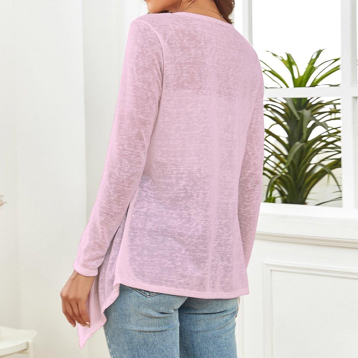 The backside of a woman wearing a pink long-sleeve top and blue jeans in a room with a plant in the background. - Printspirationz